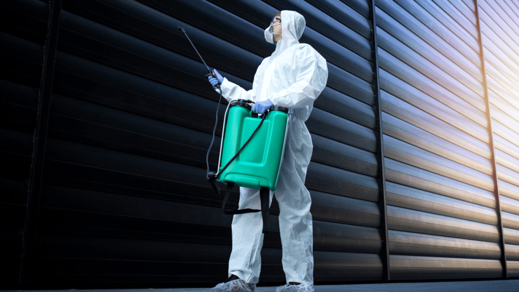 Exterminator in suit holding green container with spray