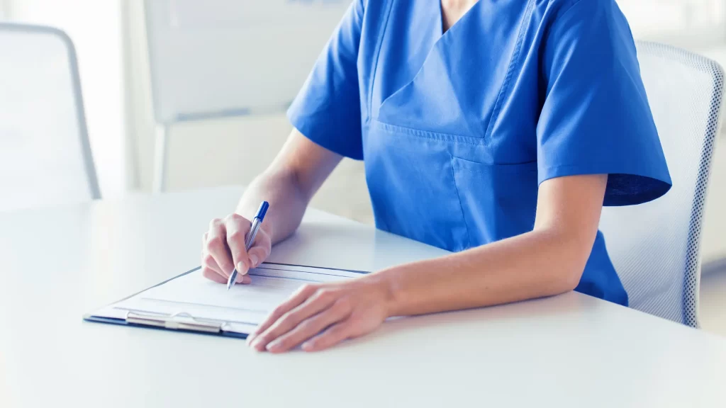 Nurse writing to clipboard illustrating What Is a Nurse Practitioner