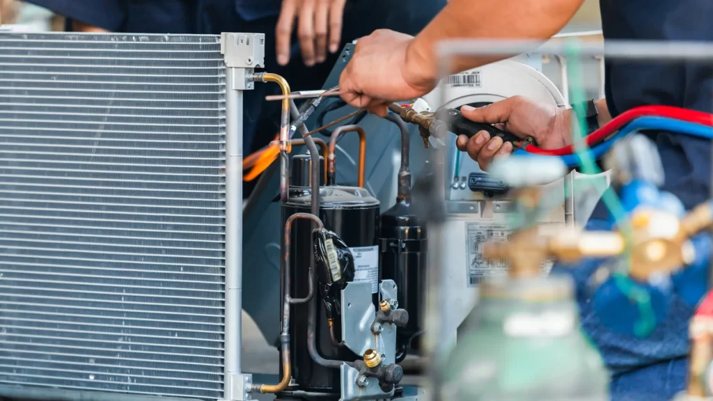 Air conditioning repair team using gases - illustrating HVAC technician salaries