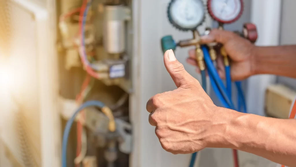 HVAC technician giving a thumbs up after checking SEER rating efficiencies, with gauges indicating operational status