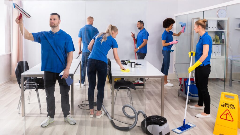 Janitors cleaning an office space with various cleaning tools and equipment