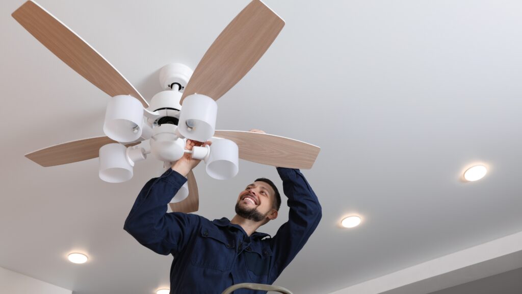 An Electrician Working on a Ceiling Fan, Offering Tips to Get the Best Deal on Installation