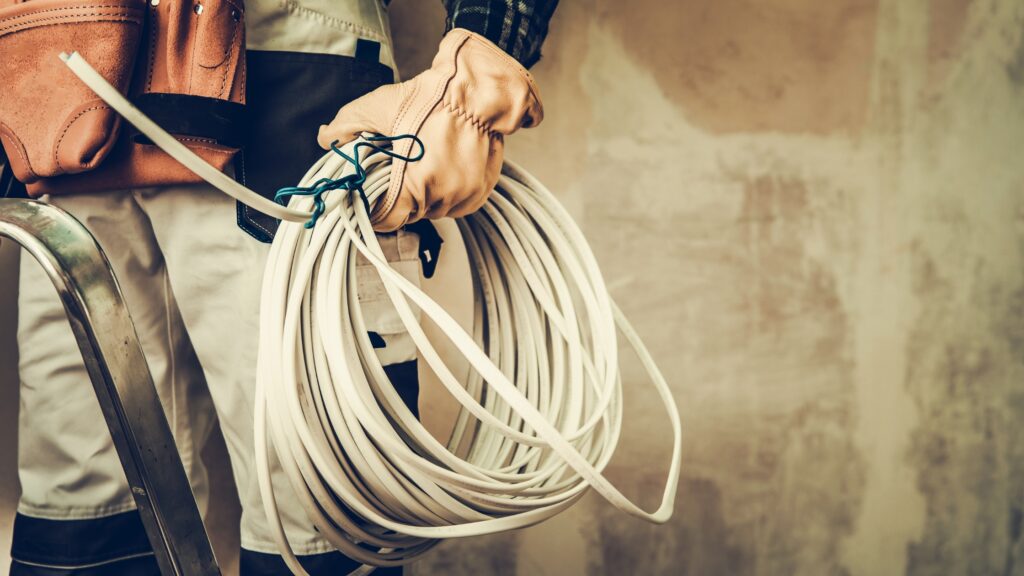 Master electrician holding electrical wires and tools, ready for a complex electrical project