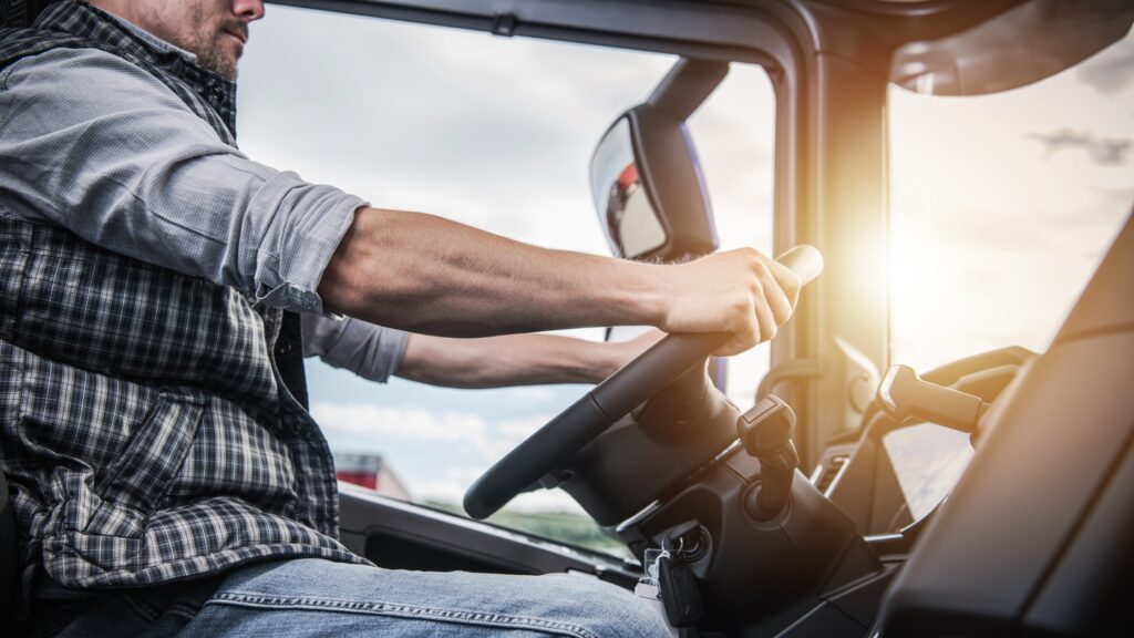 Driver's hands on the wheel illustrating how much does a truck driver make in 2024 based on experience