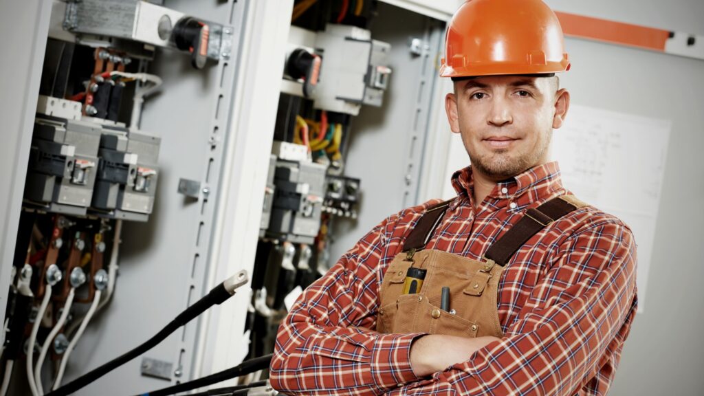 Electrician standing confidently in front of electrical panels, showcasing what an electrician does daily