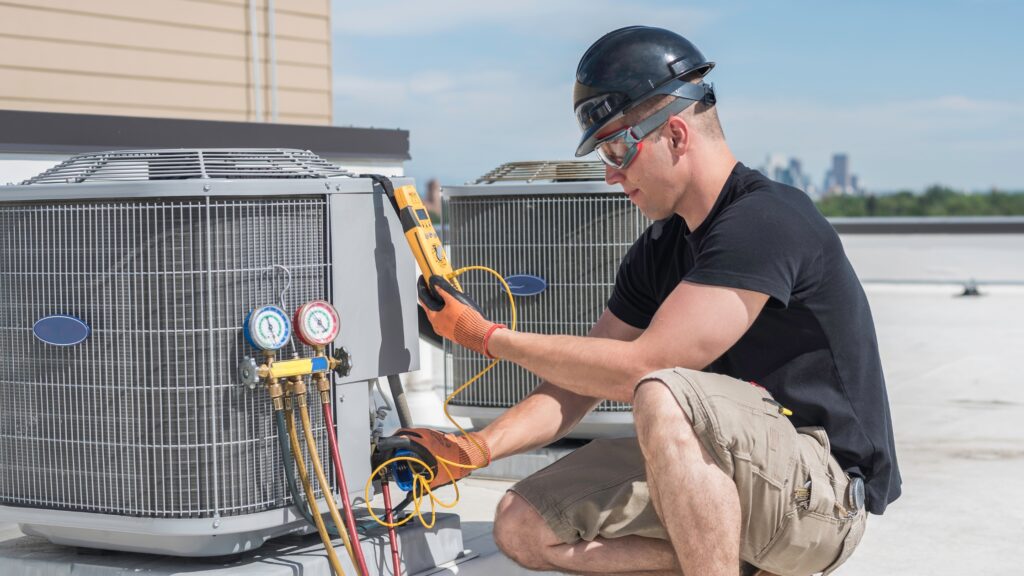 HVAC technician using a digital multimeter for diagnostics, a crucial tool in the HVAC technician tool list