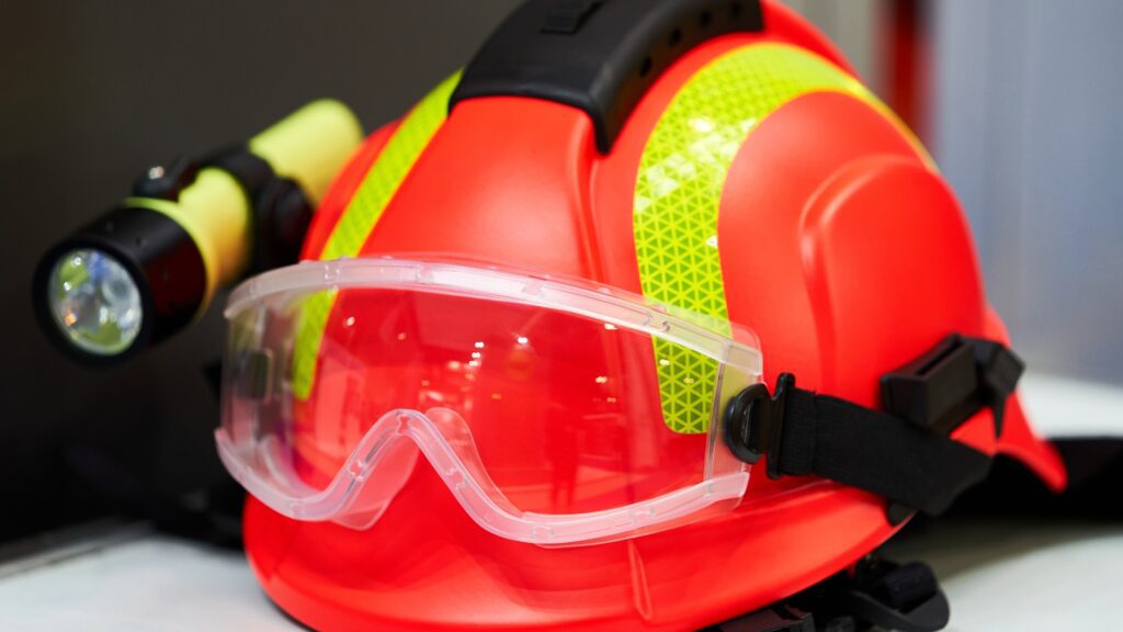 Essential safety gear for HVAC technicians, including a hard hat, safety goggles, and a flashlight, part of HVAC tool list