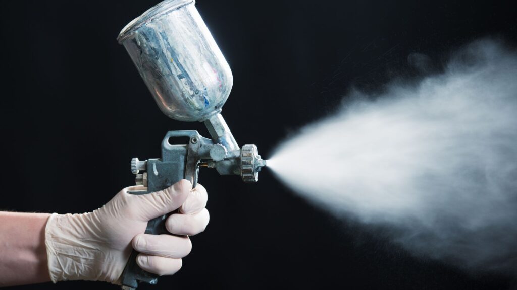 Professional painter demonstrating the power and performance of the best paint sprayers for 2024, spraying paint evenly