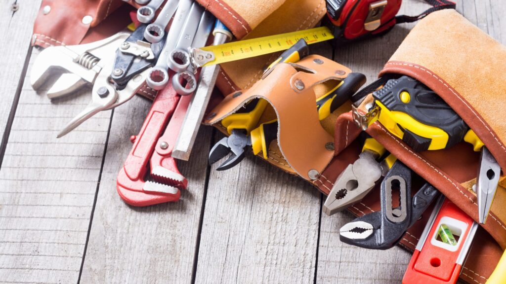 Leather tool belt filled with wrenches, pliers, and measuring tape, demonstrating storage and material choice for the best tool belt