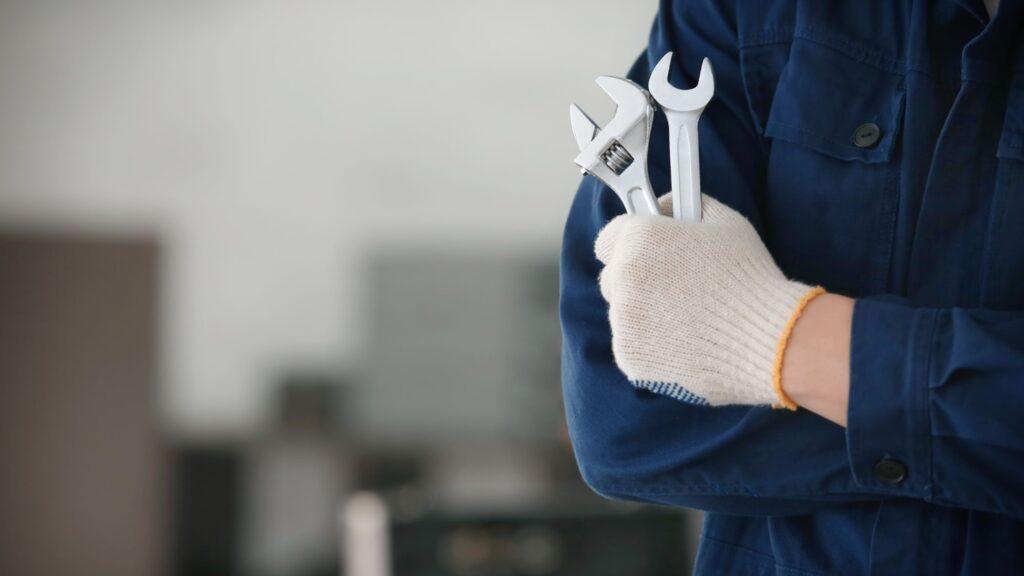 A tradesman wearing protective work gloves while holding tools, showcasing the best work gloves for tradesmen in 202