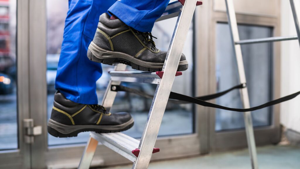 Close-up of a plumber using a stable ladder, designed for heavy loads and tight spaces in HVAC work