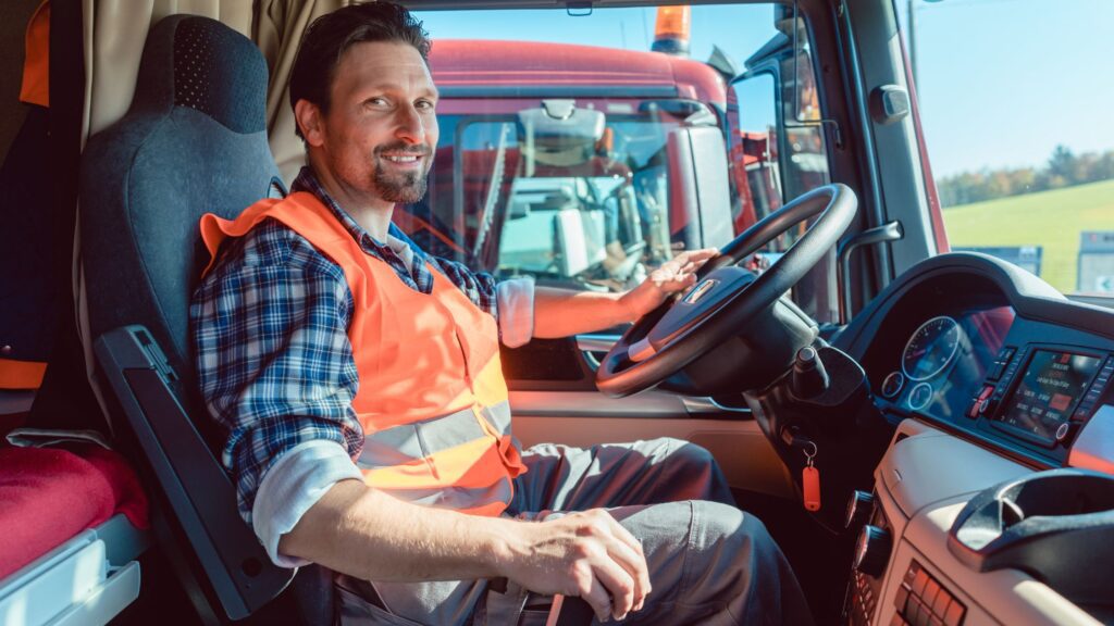 Truck driver sitting in the cab with essential safety and comfort items, ready to tackle a long road journey