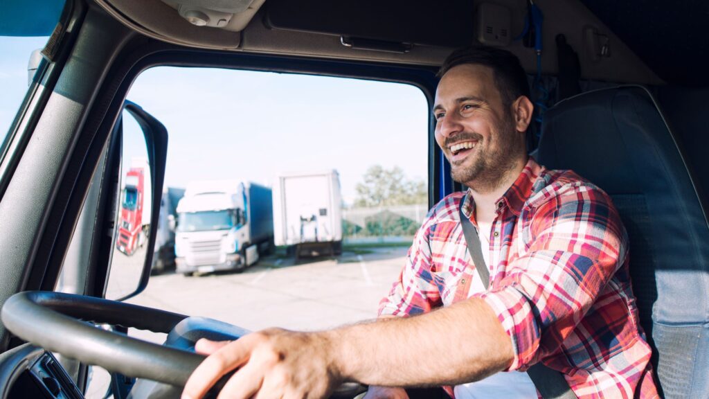 Truck driver smiling inside the cab, ready for a road trip with essential tools and supplies for a smooth journey