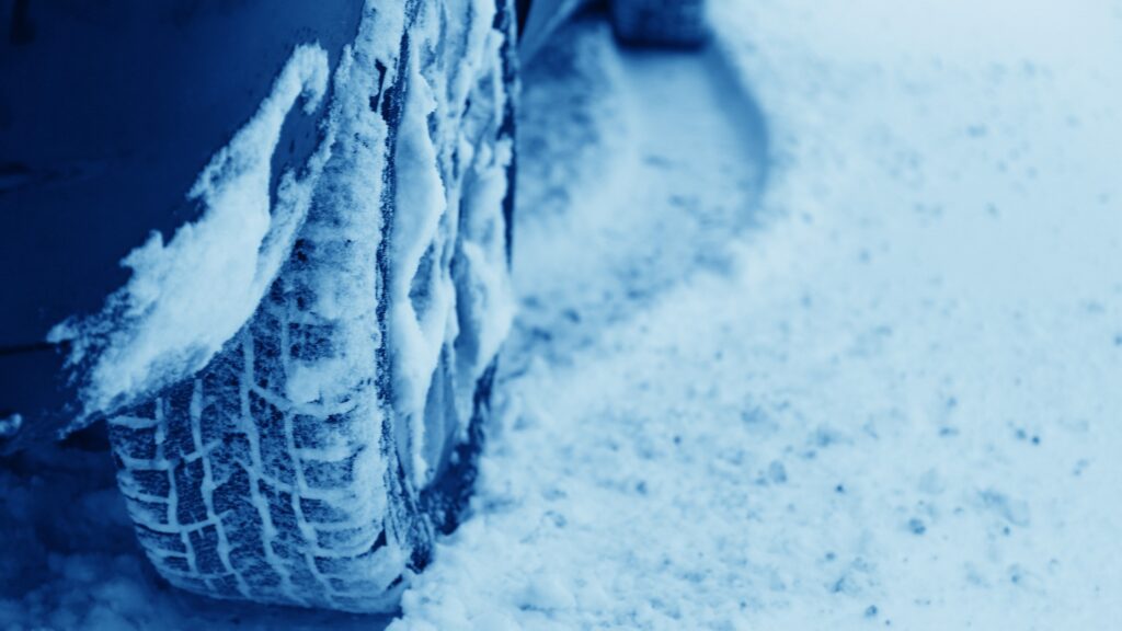 Snow-covered tire on a vehicle, emphasizing winter gear for tradesmen and proper vehicle maintenance